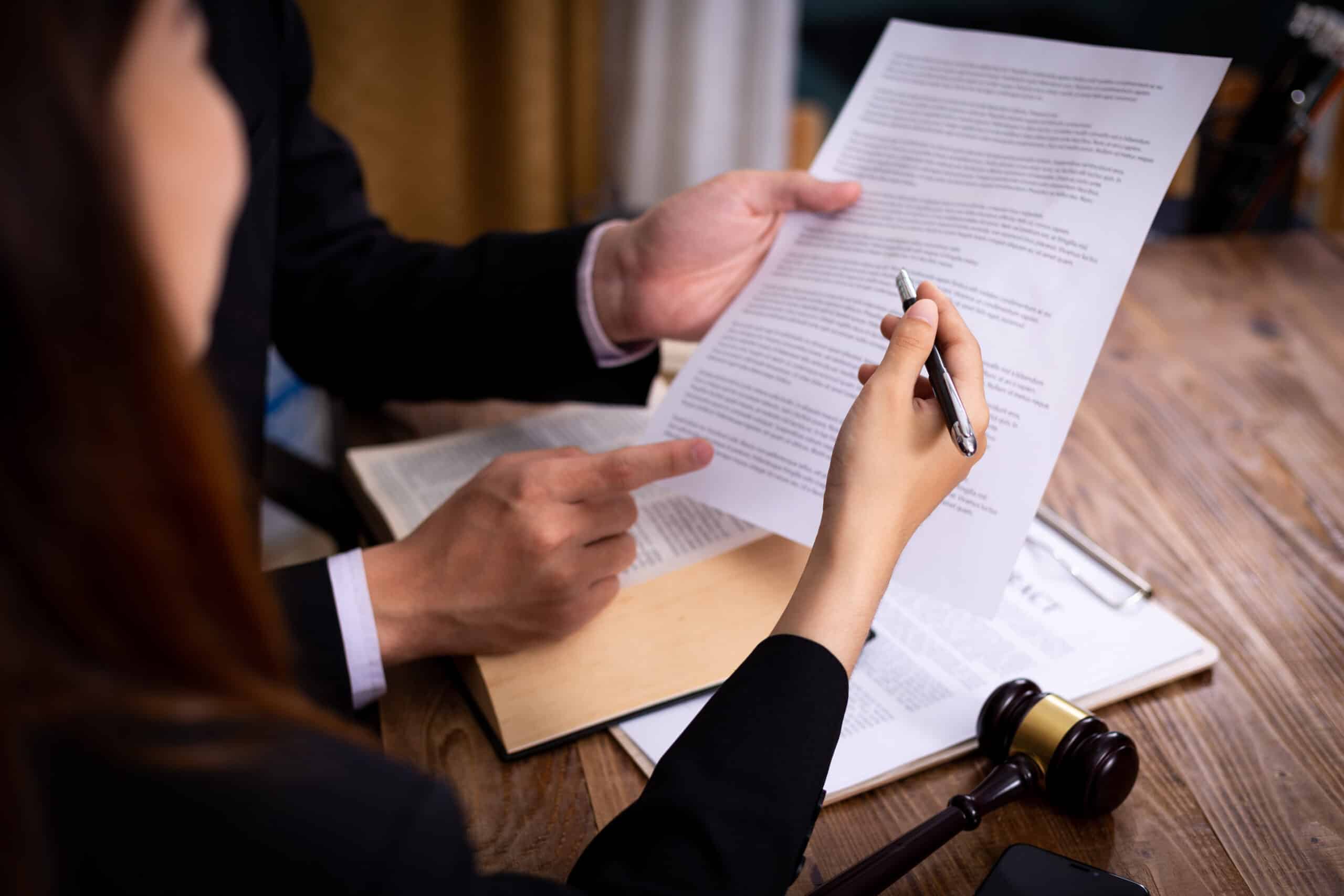 Two real estate lawyers looking at a document regarding their landlord tenant dispute case in Nassau County.
