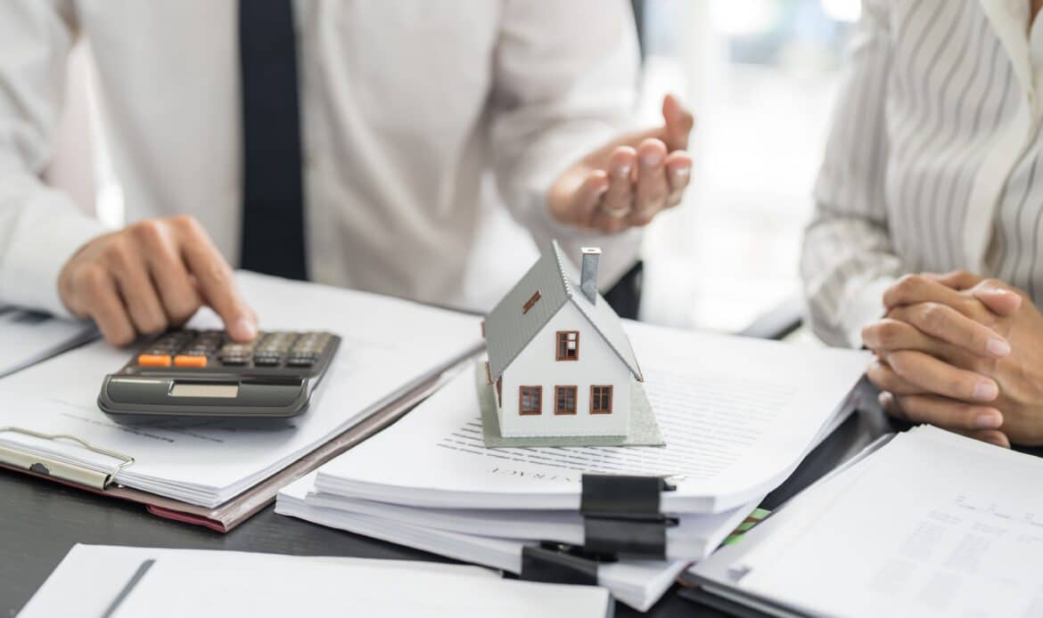 Two people discussing closing costs for a residential home purchase in Nassau County while reviewing closing documents.
